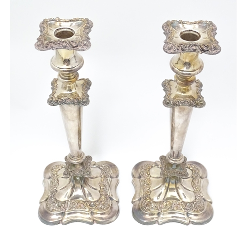 609 - A pair of silver plate candlesticks with floral and acanthus scroll decoration. 12 1/2