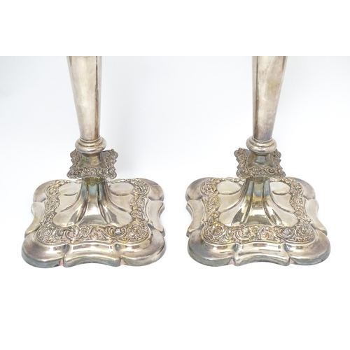 609 - A pair of silver plate candlesticks with floral and acanthus scroll decoration. 12 1/2