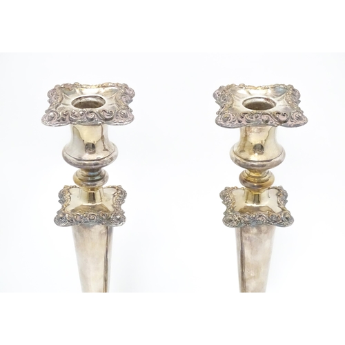 609 - A pair of silver plate candlesticks with floral and acanthus scroll decoration. 12 1/2