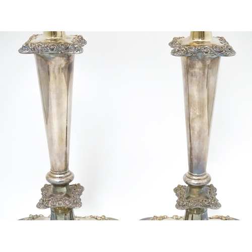 609 - A pair of silver plate candlesticks with floral and acanthus scroll decoration. 12 1/2