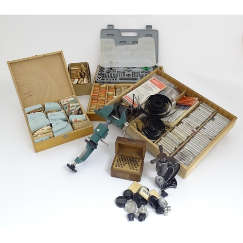 775A - A quantity of Watch / Clock makers tools etc, including cased glasses, springs, clamps and dies.