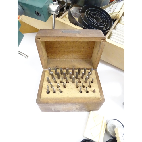 775A - A quantity of Watch / Clock makers tools etc, including cased glasses, springs, clamps and dies.