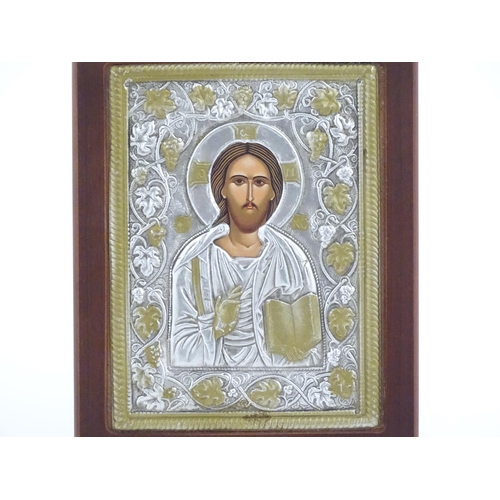 1052 - A 20thC Russian icon depicting Jesus Christ within an embossed surround bordered by fruiting vine de... 