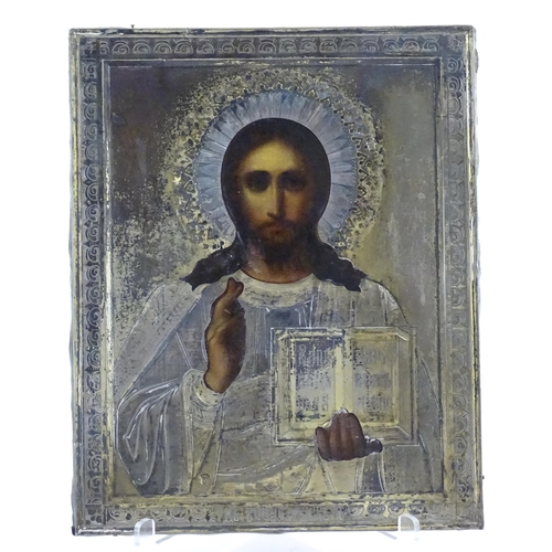 1054 - A 19thC Russian oil on panel icon depicting Christ Pantocrator with an embossed silver surround with... 