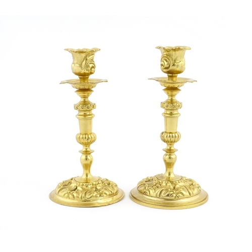 1106 - A pair of late 19th / early 20thC Continental ormolu candlesticks with foliate decoration. Approx. 8... 