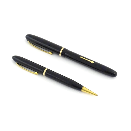 1112 - A c1950 boxed Waterman's Champion 501 black fountain pen with 14ct gold W-2B nib, matching propellin... 