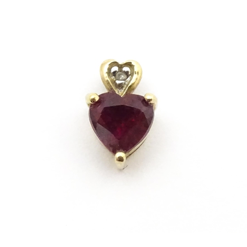 686 - A yellow metal pendant set with ruby and diamond in a heart shaped setting. Approx. 1/4