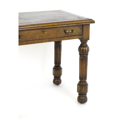 1333 - A Victorian oak desk with a moulded top and inset leather writing surface, having a frieze drawer ab... 