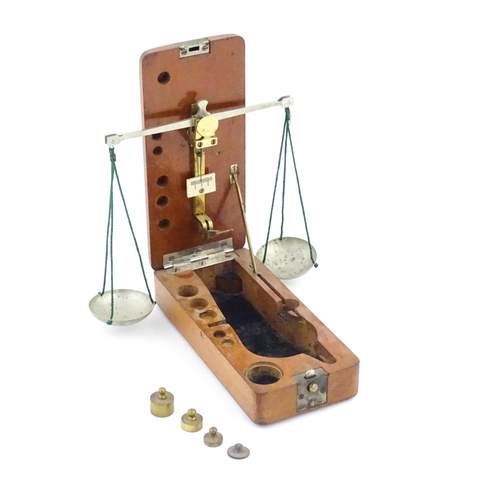 1143 - A late 19th / early 20thC apothecary / jeweller's balance scale within a fitted mahogany case, with ... 