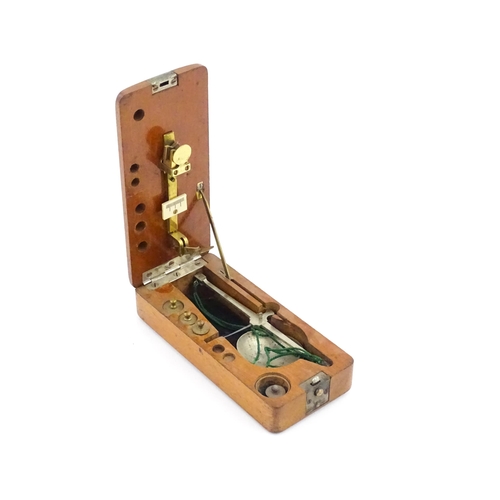 1143 - A late 19th / early 20thC apothecary / jeweller's balance scale within a fitted mahogany case, with ... 