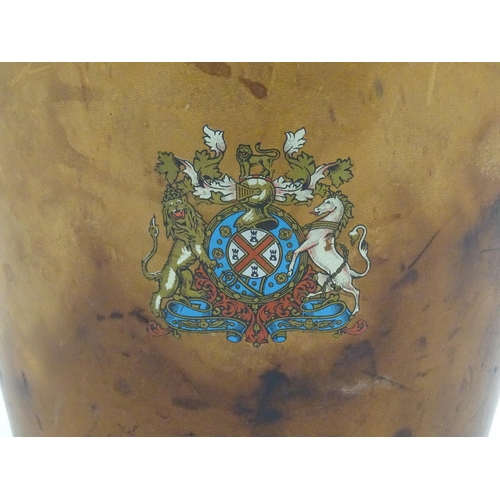 1149 - A 20thC leather covered fire bucket with swing handle and armorial / coat of arms detail. Approx. 11... 