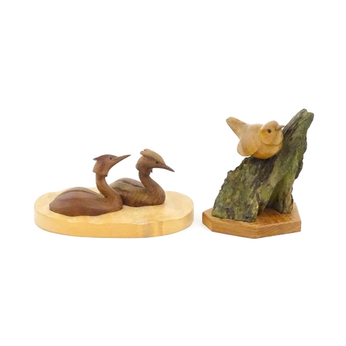 1152 - Two 20thC carved wooden bird sculptures, to include two swimming grebes, and a wren on a branch. One... 