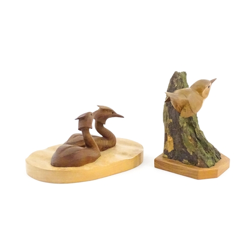 1152 - Two 20thC carved wooden bird sculptures, to include two swimming grebes, and a wren on a branch. One... 