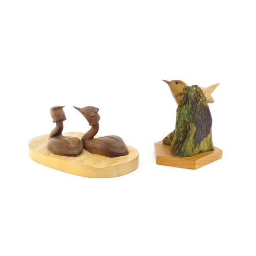 1152 - Two 20thC carved wooden bird sculptures, to include two swimming grebes, and a wren on a branch. One... 