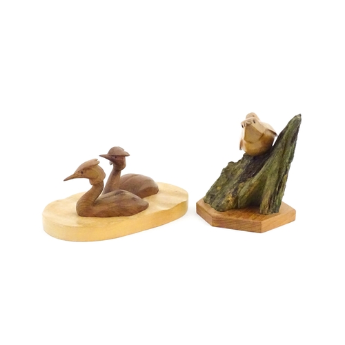 1152 - Two 20thC carved wooden bird sculptures, to include two swimming grebes, and a wren on a branch. One... 