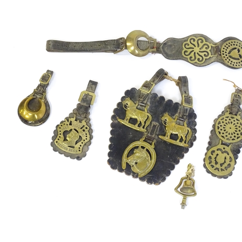 1055 - A quantity of Victorian and later horse brasses mounted to leather backing, variously decorated with... 