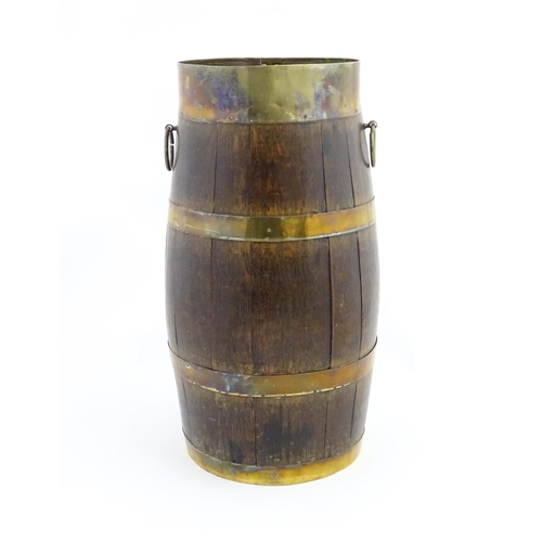 1201 - An early 20thC oak coopered barrel with brass banding and twin ring handles. Approx. 21 1/2