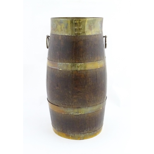 1201 - An early 20thC oak coopered barrel with brass banding and twin ring handles. Approx. 21 1/2