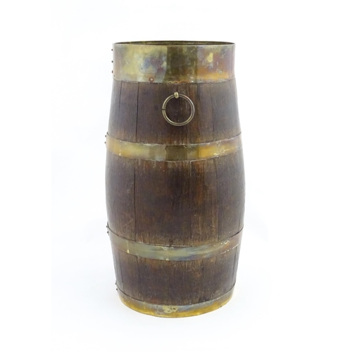 1201 - An early 20thC oak coopered barrel with brass banding and twin ring handles. Approx. 21 1/2