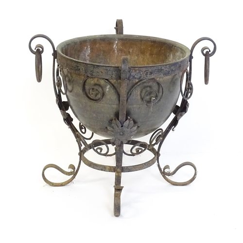 1202 - A late 19th / early 20thC copper planter / jardiniere within a wrought iron stand with scrollwork an... 