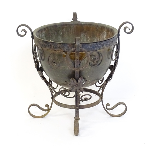 1202 - A late 19th / early 20thC copper planter / jardiniere within a wrought iron stand with scrollwork an... 