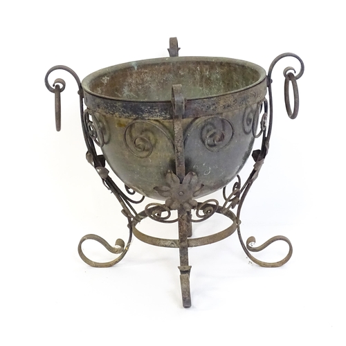 1202 - A late 19th / early 20thC copper planter / jardiniere within a wrought iron stand with scrollwork an... 