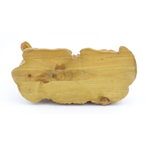 1230 - A 20thC carved wooden model of a recumbent ram / sheep. Approx. 21