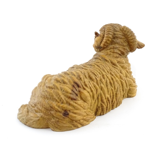 1230 - A 20thC carved wooden model of a recumbent ram / sheep. Approx. 21