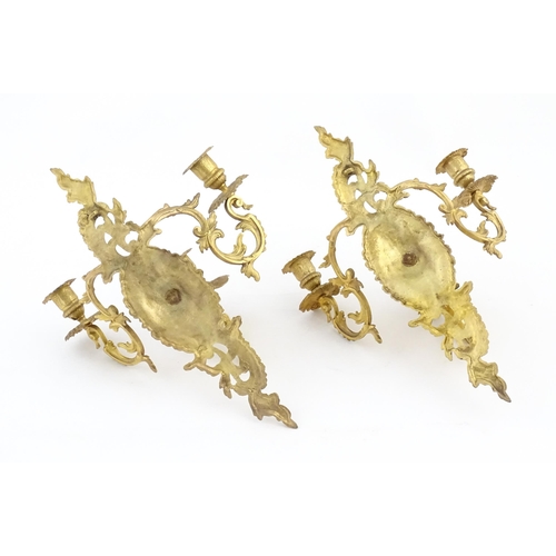 1241 - A pair of late 19th / early 20thC gilt metal three branch wall candle sconces with scrolling foliate... 