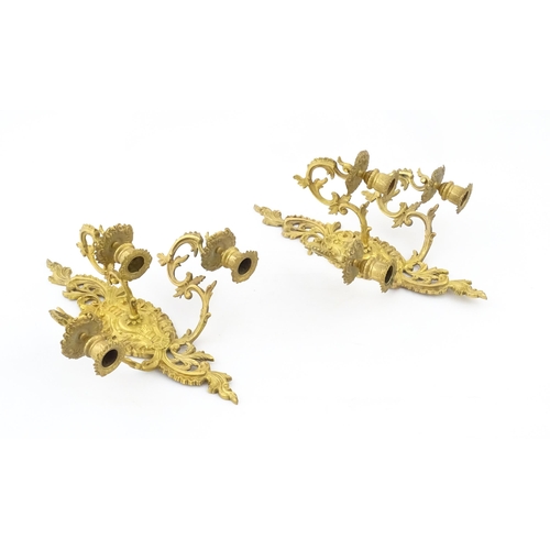 1241 - A pair of late 19th / early 20thC gilt metal three branch wall candle sconces with scrolling foliate... 