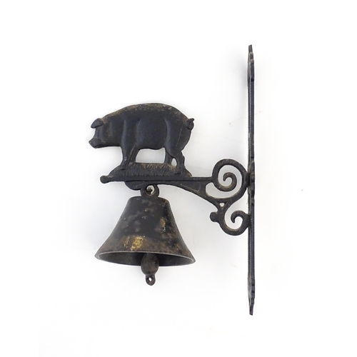 1243 - A 20thC cast wall hanging exterior bell surmounted by a pig. Approx. 15 3/4