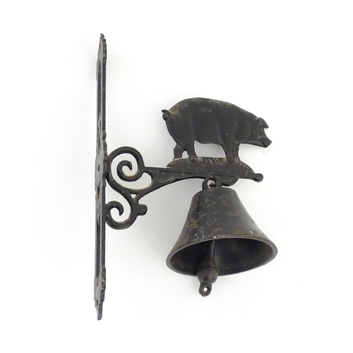 1243 - A 20thC cast wall hanging exterior bell surmounted by a pig. Approx. 15 3/4