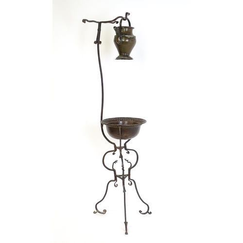 1247 - A wrought iron washstand, the scrolling tripod base with copper bowl / basin, the upstand with hangi... 