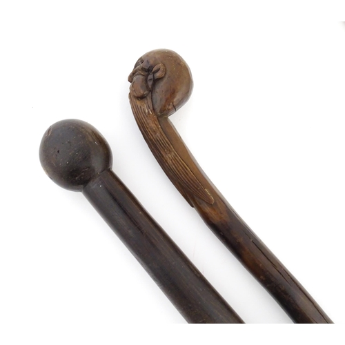 1251 - Four walking sticks, comprising a native tribal example with knop handle, an oriental stick with car... 