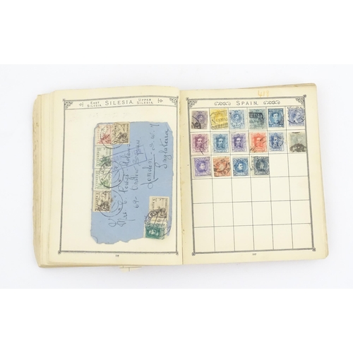 1194 - An early 20thC postage stamp album, containing numerous affixed worldwide stamps including 19thC and... 