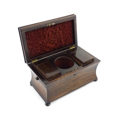 1197 - A 19thC rosewood tea caddy of sarcophagus form raised on four squat bun feet, the hinged lid opening... 