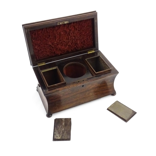 1197 - A 19thC rosewood tea caddy of sarcophagus form raised on four squat bun feet, the hinged lid opening... 