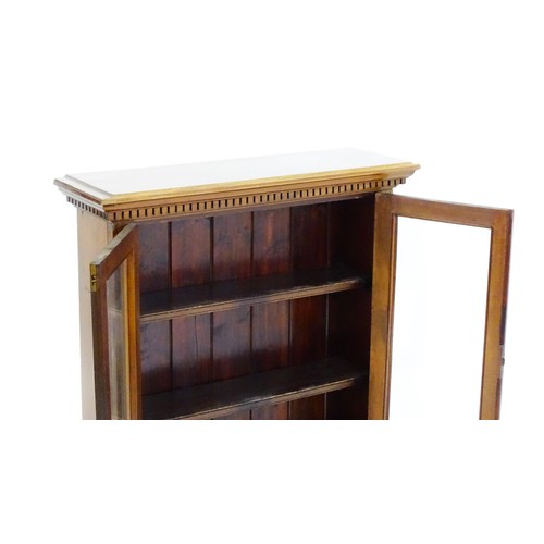 1367 - An early 20thC walnut bookcase with a moulded cornice above a dentil craved frieze with two glazed d... 