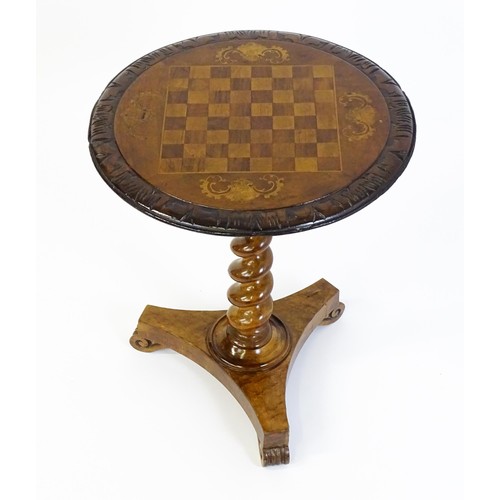 1396 - A 19thC tripod table with a circular top inlaid with a chessboard, floral decoration and a carved su... 