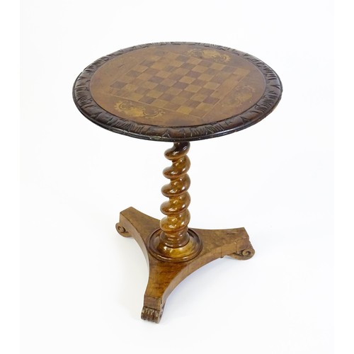 1396 - A 19thC tripod table with a circular top inlaid with a chessboard, floral decoration and a carved su... 