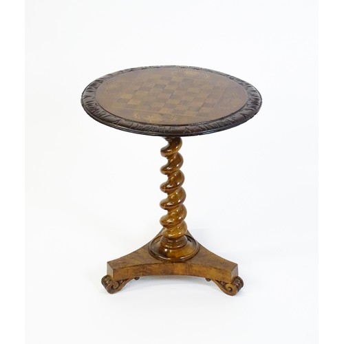 1396 - A 19thC tripod table with a circular top inlaid with a chessboard, floral decoration and a carved su... 