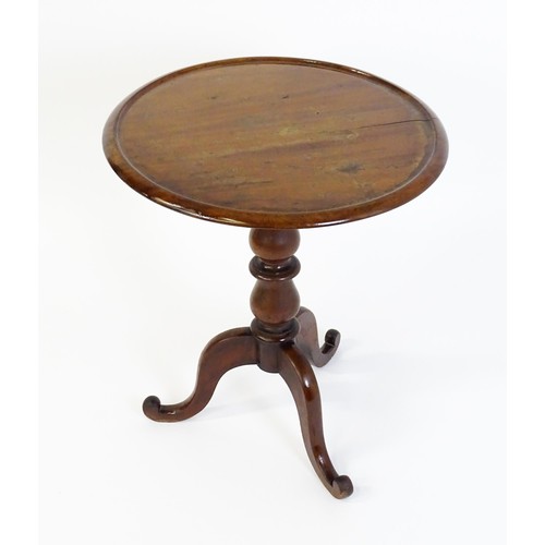 1353 - A Victorian mahogany tripod table with a circular dished top above a turned pedestal and three cabri... 