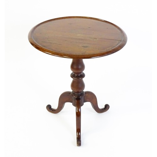 1353 - A Victorian mahogany tripod table with a circular dished top above a turned pedestal and three cabri... 