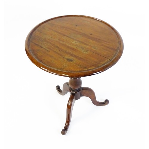 1353 - A Victorian mahogany tripod table with a circular dished top above a turned pedestal and three cabri... 