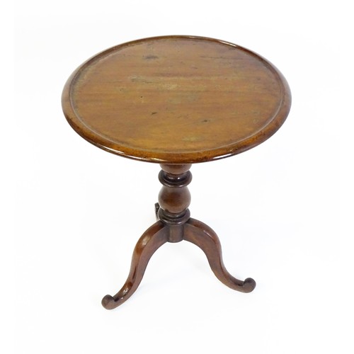 1353 - A Victorian mahogany tripod table with a circular dished top above a turned pedestal and three cabri... 