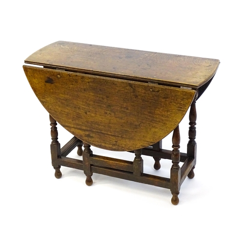 1332 - An early 18thC oak drop leaf table with a small drawer to end, the two leaves opening to form and ov... 