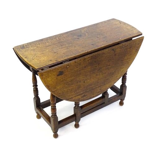 1332 - An early 18thC oak drop leaf table with a small drawer to end, the two leaves opening to form and ov... 