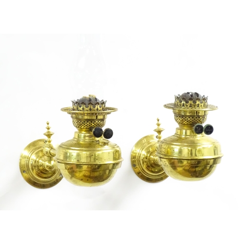 1313 - A pair of early 20thC oil lamps, the adjustable wall mounts supporting duplex burners, each approx 1... 