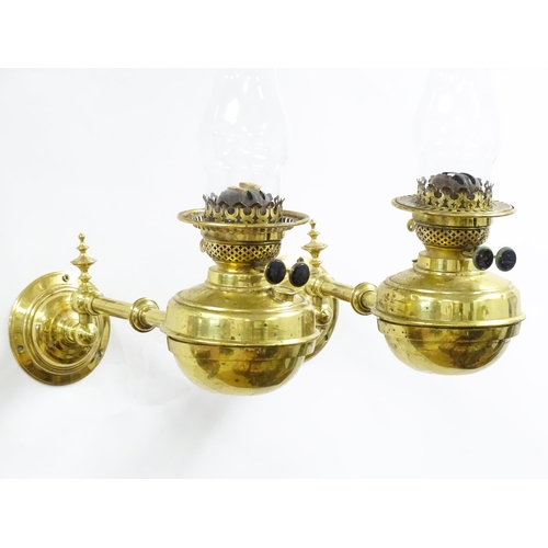 1313 - A pair of early 20thC oil lamps, the adjustable wall mounts supporting duplex burners, each approx 1... 