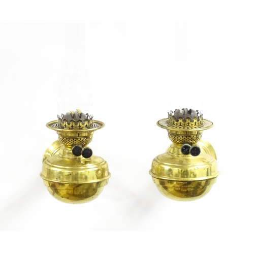 1313 - A pair of early 20thC oil lamps, the adjustable wall mounts supporting duplex burners, each approx 1... 